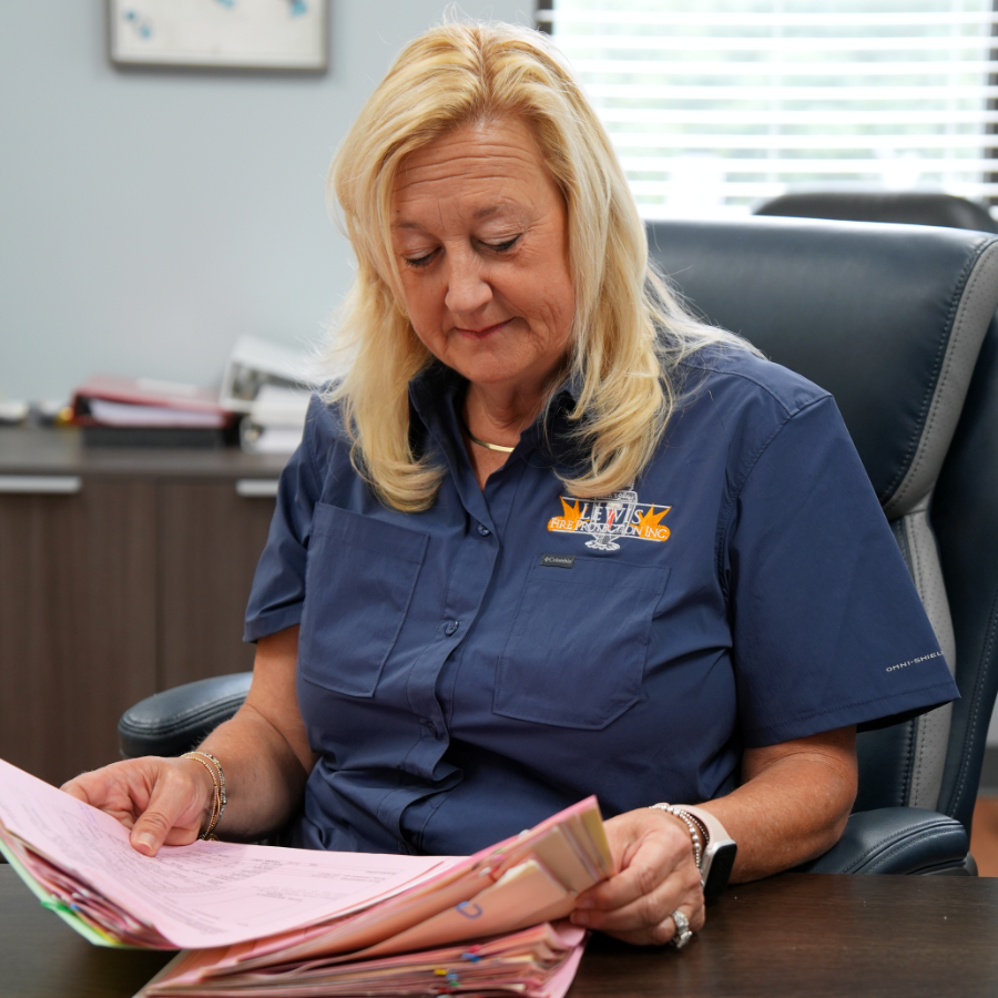 Tina Maxian sitting at her desk, looking through paperwork.